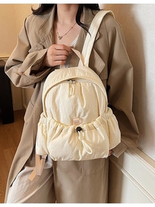 Minimalist cream nylon backpack for women with drawstring pockets and a lightweight design