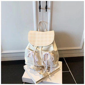 Close-up of beige plaid拼接 backpack with white lace bow and PU leather texture details