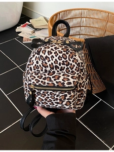 Fashionable leopard print mini backpack with cute black bow detail and gold zippers