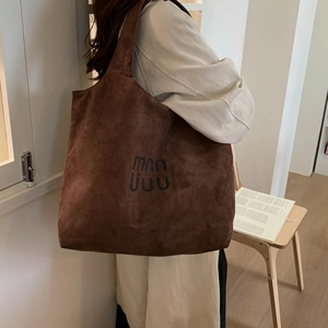 Brown suede tote bag side view on model showing large capacity and soft texture