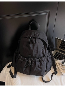 Minimalist black canvas backpack for women with drawstring front pocket and dual zippers