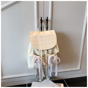 Detailed view of cream-white checkerboard backpack featuring lace bow and drawstring pockets