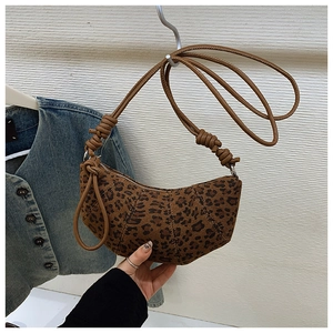 Detail of leopard print crescent bag showing quilted canvas texture and knotted strap