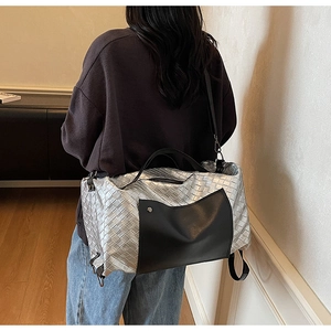 Grande borsa da viaggio intrecciata argento con dettagli in pelle nera per sport.