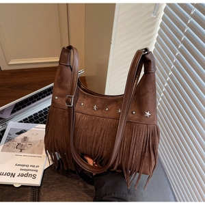 Dettaglio borsa in camoscio marrone con frange e borchie metalliche a forma di stella