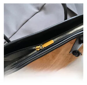 Macro detail of high-quality gold metal zipper on brown vintage suede shoulder bag