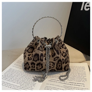 Detail of leopard print bucket bag featuring metal ring handle and fringe drawstring