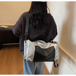 Dettaglio borsa in pelle intrecciata argento con tasca nera e tracolla regolabile larga