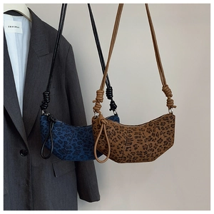 Detail of trendy leopard print crescent bags with unique knotted shoulder strap design
