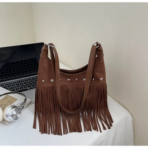 Dettaglio della borsa in pelle scamosciata marrone con frange e borchie a stella