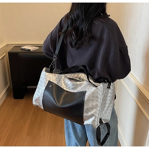 Dettaglio della borsa da viaggio in pelle intrecciata argento con tasca nera su modella