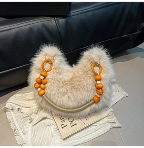 Détail du sac à main en fourrure avec perles oranges et poignée tissée sur magazine