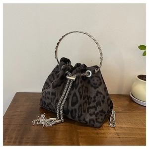 Detail of leopard print bucket bag with silver metal ring handle and rhinestone tassels