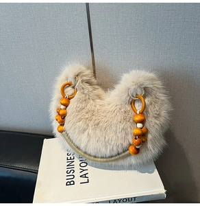 Détail du sac en fausse fourrure avec perles en bois orange et poignée tissée dorée