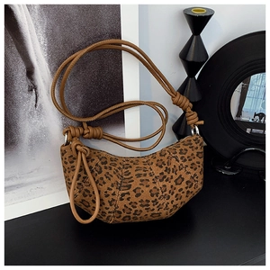 Detail of leopard print crescent bag featuring a stylish knotted shoulder strap design