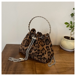 Detailed close-up of leopard print bucket bag with silver metal ring handle and chain