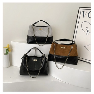 Three suede tote bags with quilted base and gold chain straps on minimalist white steps