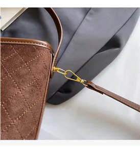 Detailed view of brown quilted suede handbag with luxury golden metal clasp hardware