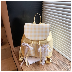 Close-up of yellow plaid backpack with white lace bows and drawstring pocket details