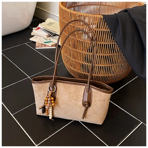 Detail of vintage quilted suede tote bag with bohemian beaded tassel and brown trim