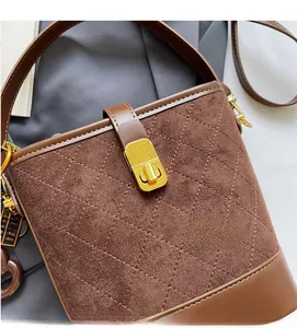 Macro detail of brown quilted suede bucket bag with gold clasp and leather trim