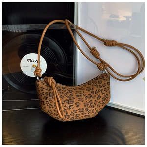 Detail shot of leopard print hobo bag with knotted brown leather strap and zip closure