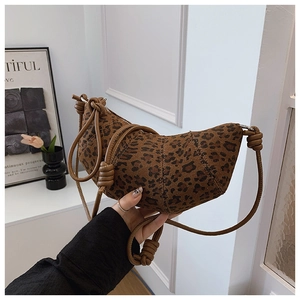 Close-up of leopard print crescent bag featuring a textured finish and rope shoulder strap