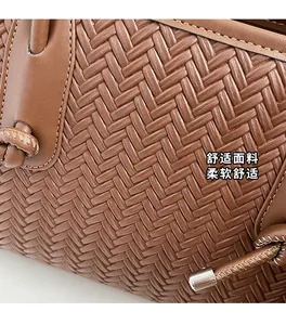 Gros plan du sac cabas marron tissé avec texture à chevrons et finitions en métal argenté