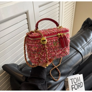 Detail of pink and green tweed texture on structured handbag with gold floral clasp