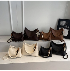 Detail showing vintage half-moon shoulder bags in four colors and two sizes on display