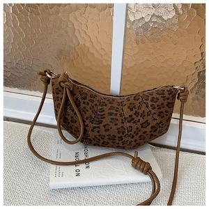 Close-up of leopard print canvas fabric with brown leather strap and creative knot detail