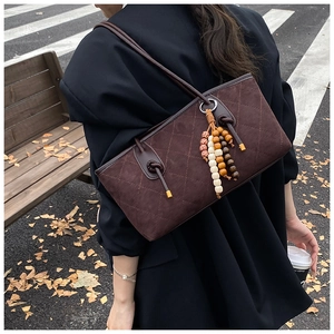 Detail of vintage quilted coffee tote bag with decorative beaded tassel charm