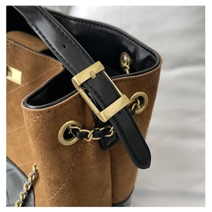 Detail of adjustable leather strap and gold buckle on vintage suede quilted tote bag
