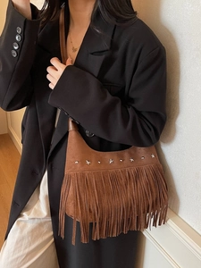 Borsa a tracolla boho in camoscio marrone con stelle metalliche e lunghe frange su modella