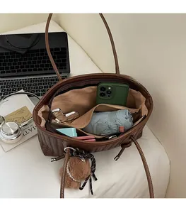 Vue intérieure du sac cabas tressé marron montrant sa grande capacité et sa fermeture