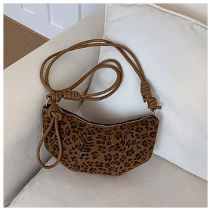Detailed view of the leopard print croissant bag with textured stitching and knotted strap