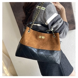 Quilted black leather and brown suede tote bag featuring a gold turn-lock and chain strap