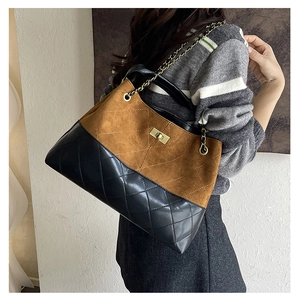 Detail showing mixed texture of brown suede and black quilted leather with chain strap