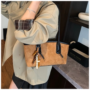 Side view of caramel brown suede tote bag with black leather trim and bead charms