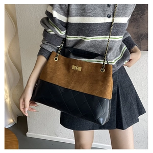 Detail of suede and quilted leather patchwork with gold chain strap and metal clasp