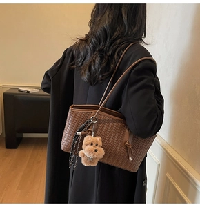 Sac fourre-tout tressé marron avec charme de chien et perles porté par un mannequin