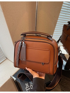 Brown vintage pebbled leather crossbody handbag with wide shoulder strap and dual zippers