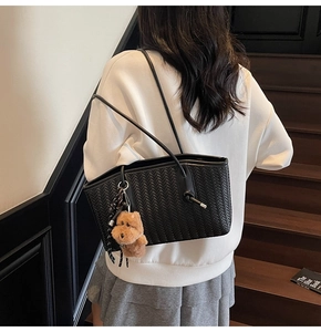 Détail du tissage noir sur le sac cabas avec un charmant petit ours en peluche brun
