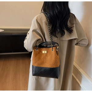 Detail of vintage suede bucket bag with diamond stitching and golden twist lock