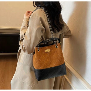Detail of vintage suede bucket bag featuring diamond quilting and gold twist lock clasp