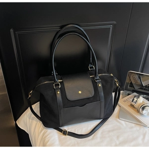 Détail du sac fourre-tout noir mat avec ferrures et poche à rabat magnétique