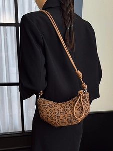Brown leopard print crescent bag with knot strap and silver zipper closure on model