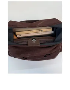 Macro view showing internal zipper compartment and magnetic closure of brown suede tote