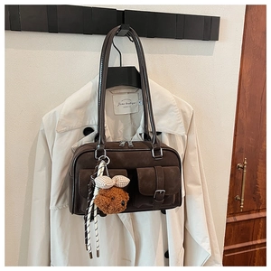 Detail of vintage brown Boston shoulder bag featuring twin front pockets with metal buckles