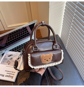 Detail of vintage brown mini bag featuring a cute plush bear patch and lace trim detail
